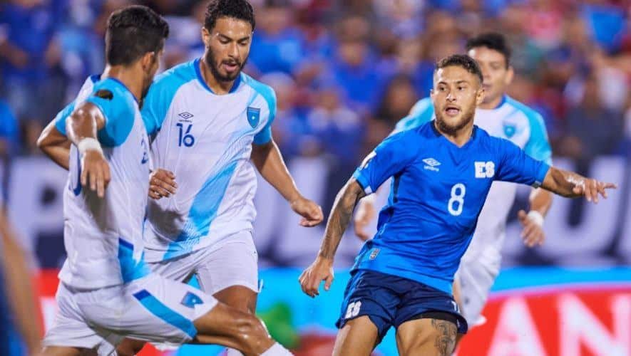 Jogadores de futebol em uma cancha, usando uniformes.