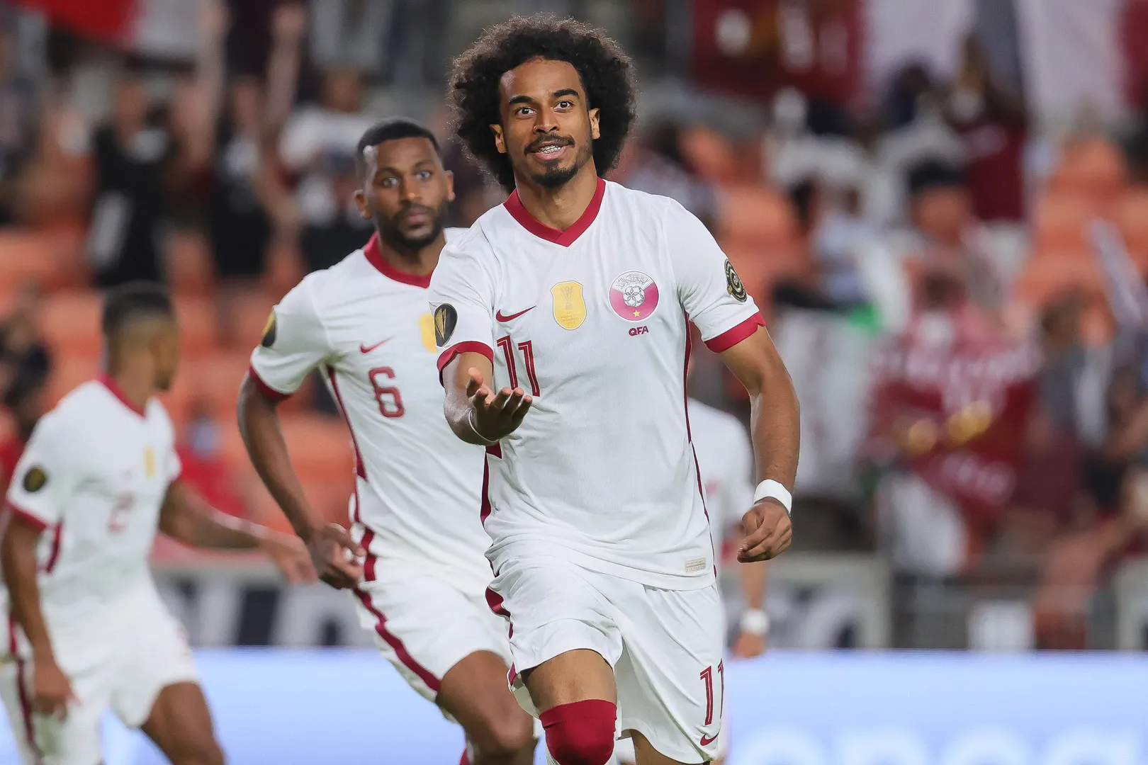 Jogador número 11 comemorando gol pela seleção do Catar.