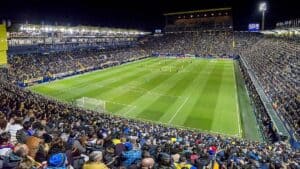 ESTADIO-la-ceramica - Gambyl Sports Betting Exchange Stadium filled with spectators watching a soccer match under bright floodlights during nighttime.